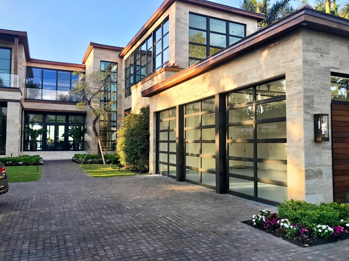 Black-framed impact windows and glass garage doors on a Miami home